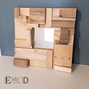 Miroir avec cadre en bois recyclé, présentant un motif mosaïque unique, accroché au mur d'une pièce lumineuse.